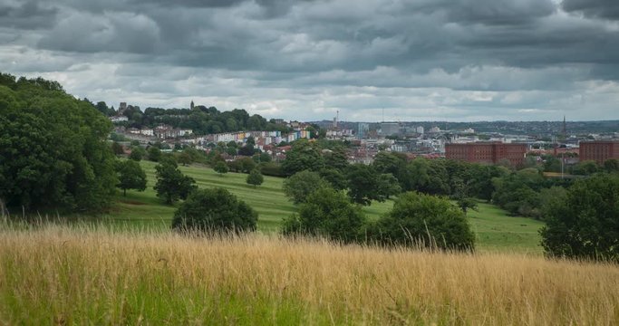 Time lapse of city of Bristol in distance beyond fields & meadows