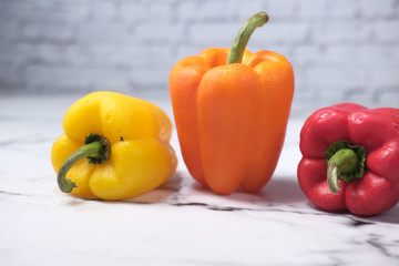 Yellow orange and red capsicum on table 
