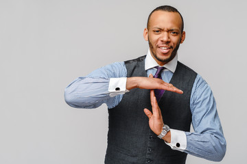 Young african american businessman showing a pause time out gesture with hands - body language...