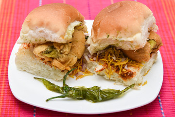 Vada Pav or pav bhaji usually served with tomato sauce, sweet, green chutney. Indian fast food, street food snack, North India, Maharashtra. vada sandwiched between two slices, loaf of bread.