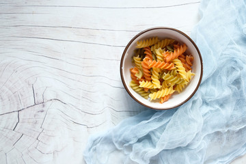 Variety of types and shapes of dry Italian pasta in a bowl.