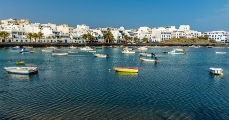 Fototapeta na wymiar A view of small boats moored in the lagoon of Charco de San Gines in Arrecife, Lanzarote on a bright sunny afternoon