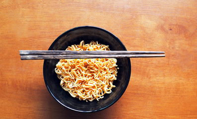 rice noodles with chopsticks and black color bowl on wooden table , Chinese & Asian Food 