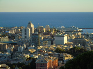 Genoa, Italy – August 2020: Aerial view of shipping and container terminal, stacked containers and loading dock side cranes in the port of Genoa, Magazzini del cotone and Porto Antico, sea