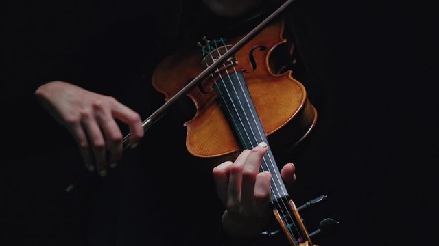 Girl violin musician playing at studio. Studio black background