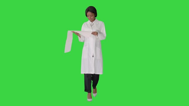 Smiling african american female doctor reading cardiogram on a Green Screen, Chroma Key.