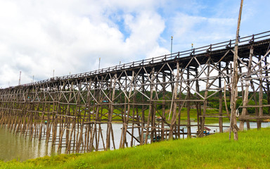 Fototapeta premium View of wooden bridge across the river and blue sky.