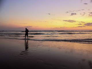 
Silhouette of a man by the ocean at sunset