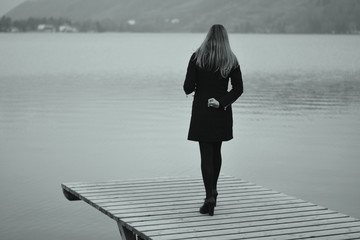 the sad woman in front of the lake in autumn