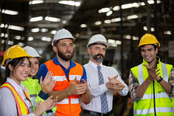 Group of Engineer manager and Factory Workers Team standing against production line.