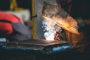 a worker in the steel industry performs electric welding