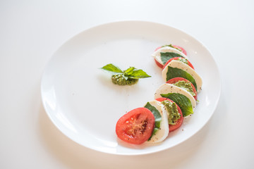 Caprese salad on white plate. Soft selective focus. Healthy concept.