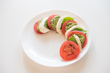 Caprese salad on white plate. Soft selective focus. Healthy concept.