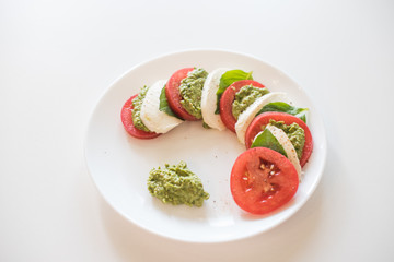 Caprese salad on white plate. Soft selective focus. Healthy concept.