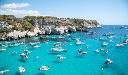 Menorca, Spain, Balearic Islands, Cala Macarella beach, anchored boats by cliffs