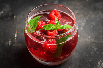 Raspberry and mint cocktail in glass on the rustic background. Selective focus. Shallow depth of field.
