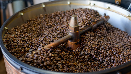 Coffee beans is roasting in roaster machine in coffee shop.