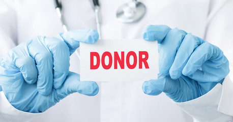 Doctor holding a card with text DONOR, medical concept