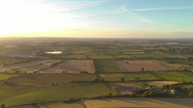 Aerial view of meadows at golden hour, English countryside scenic drone shot