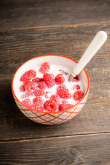 Milk with raspberry in the bowl. Selective focus. Shallow depth of field.
