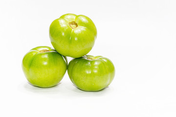 Green tomatoes over white isolated background.