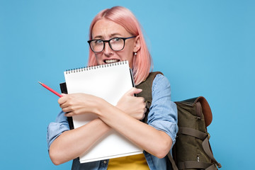 Nervous worried female studen feels anxious before exam, keeps textbook closely