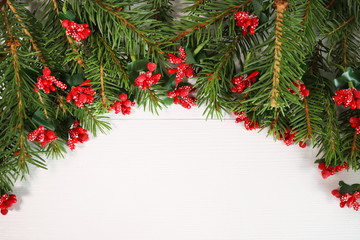 Wide arched christmas border isolated on white composed of fresh fir branches and ornaments in red