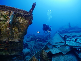 scuba divers exploring shipwreck scenery underwater ship wreck deep blue water ocean scenery of...