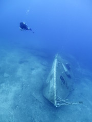 scuba divers exploring shipwreck scenery underwater ship wreck deep blue water ocean scenery of metal underwater and fish around