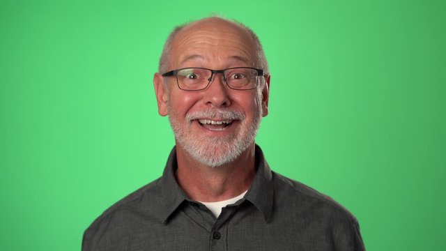 Man shocked, saying WOW. Handsome guy with bald gray hair surprised to camera on green screen background.