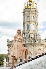 Fototapeta premium Portrait of a young girl in beige dress against the background of the Temple