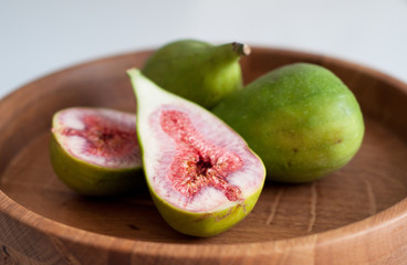 Ripe figs cut on a wooden plate. Soft focus.