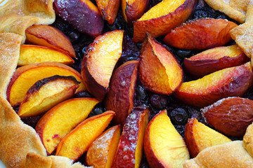 Homemade rustic galette pastry with fresh peaches and blueberries