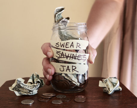 Swear jar to prevent swearing, filled with money