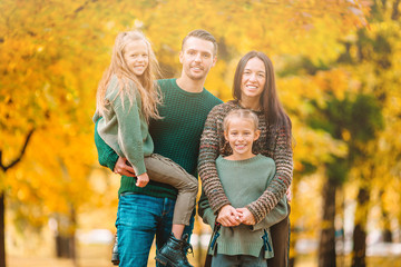 Portrait of happy family of four in autumn day