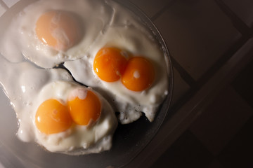 Fried eggs in a frying pan top view. An egg with two yolks.