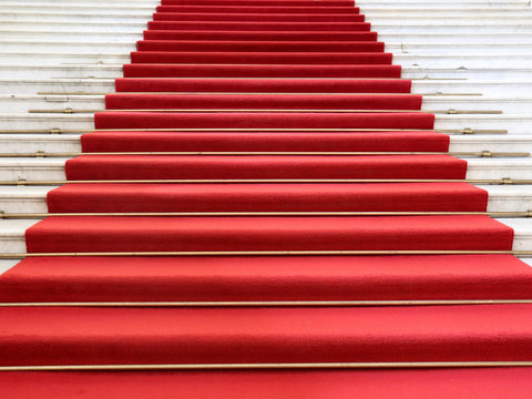Red carpet on the white marble staircase. Rise up. Go up.