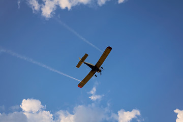airplane flying above clouds at sunset