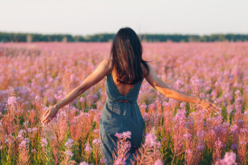 Girl on blooming Sally flower field. Lilac flowers and woman