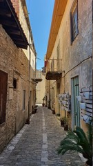 Fototapeta na wymiar narrow street in the old town. picturesque narrow street lined with stone houses with wooden windows and doors in a village in cyprus