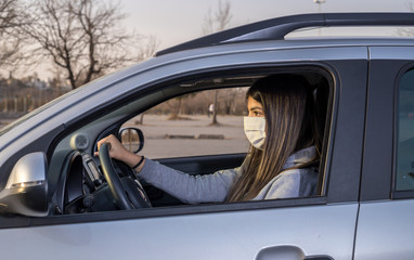 Woman with protective mask driving a car on the road. Infection prevention and epidemic control. World pandemic. Stay safe.19. Selective focus.