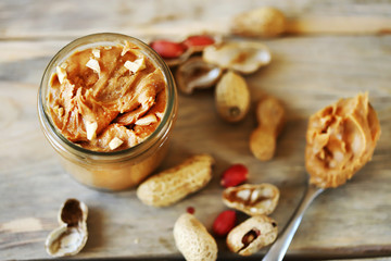 Selective focus. Peanut butter in a jar. Peanuts in the skin.