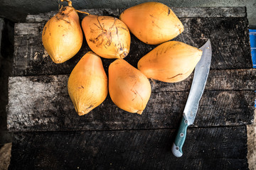 overhead view of king coconut preparation. Rustic authentic chopping board and 