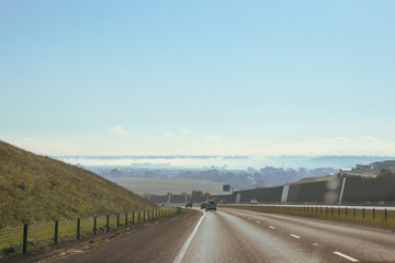light traffic on freeway with fog below