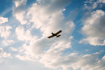 airplane flying above clouds at sunset