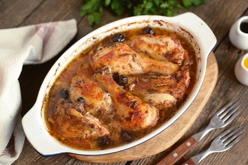 Baked chicken drumsticks and thighs with onions, garlic, olives and tomatoes. Organic food.