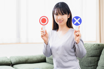 OKとNGのプラカードを持つ若い女性