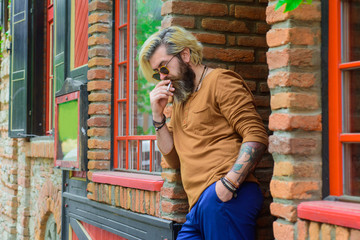 Bearded man smoke the cigarette. Stylish hipster with cigarette. Cigarette smoke. Sensual man smoking outside. Tobacco. Smoking hipster. Sensual bearded man with cigarette.