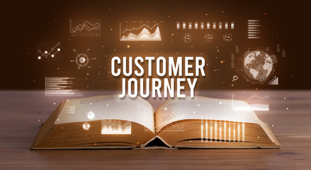 CUSTOMER JOURNEY inscription coming out from an open book, creative business concept