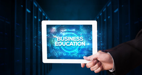Young business person working on tablet and shows the inscription: BUSINESS EDUCATION, business concept